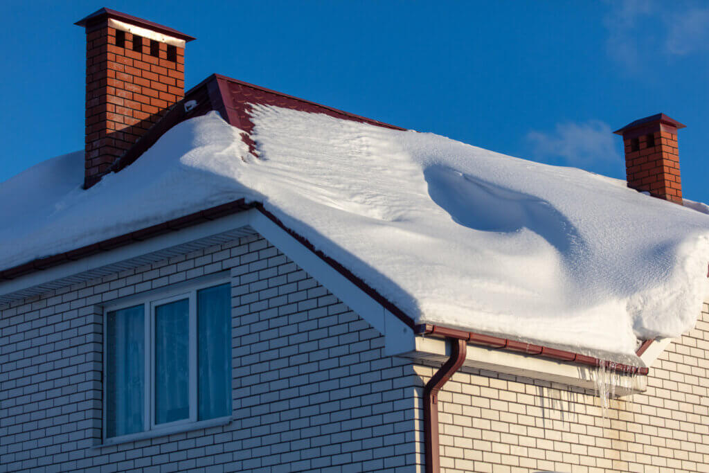 Brick house with snow on the roof in winter.