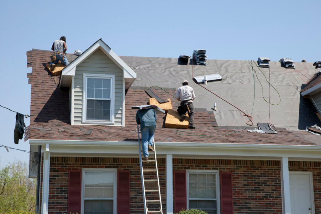 Roofing Contractors installing impact-resistant shingles