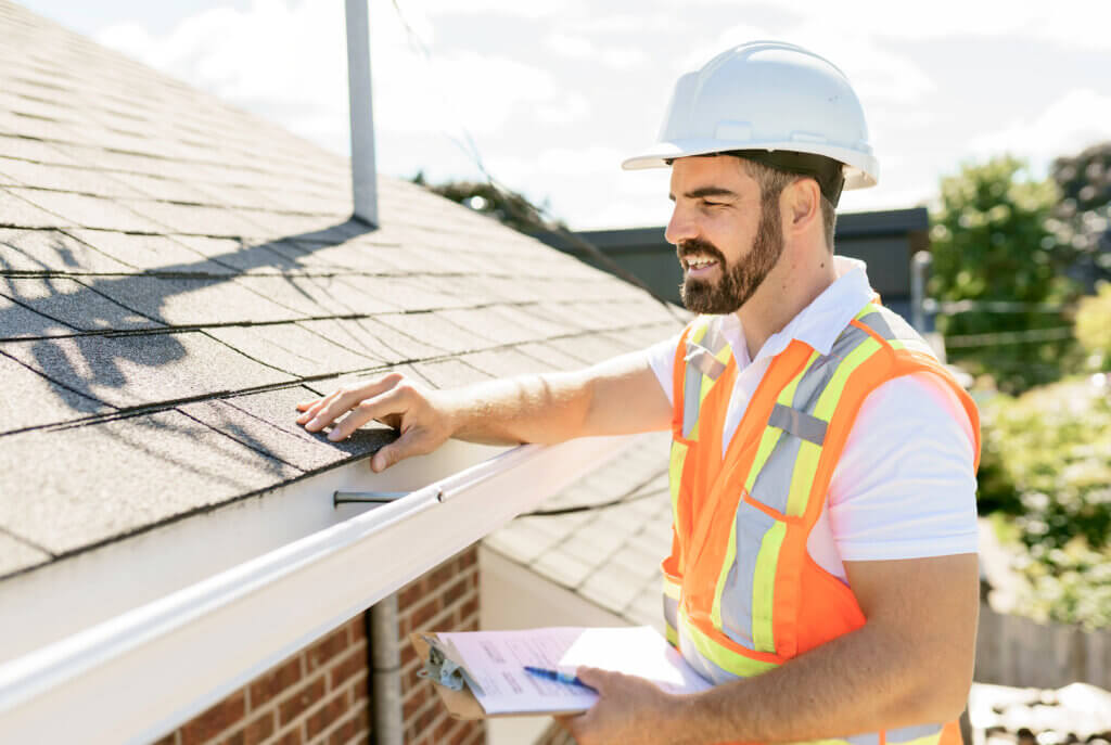 Roofer doing a fall roof inspection before winter